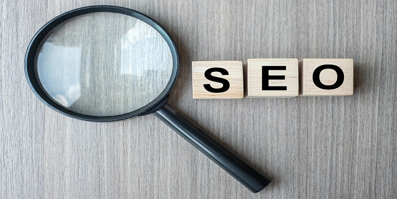 SEO (Search Engine Optimization) text wooden cubes and magnifyin